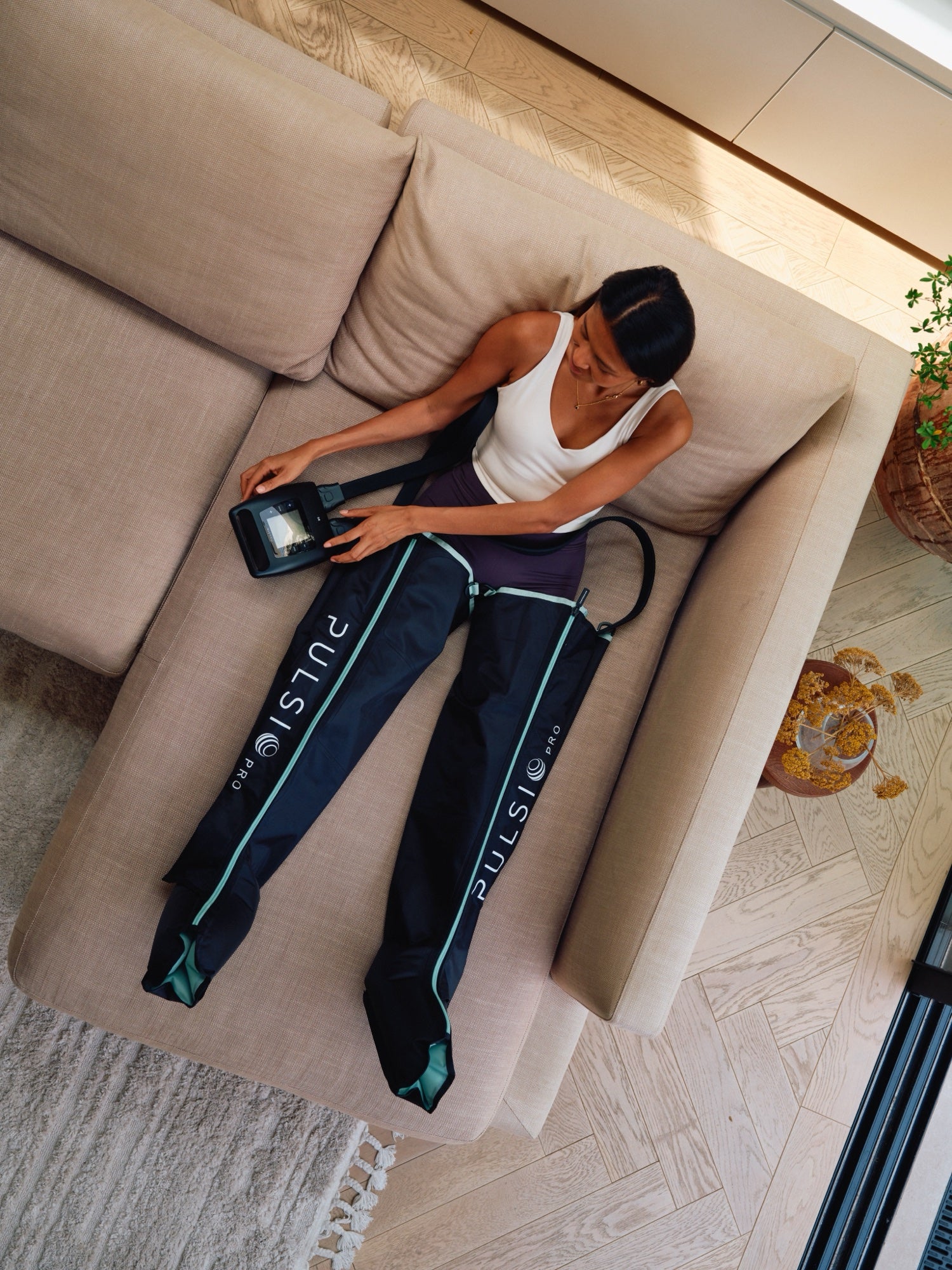 Compression PRO Boots bei der Anwendung auf dem Sofa