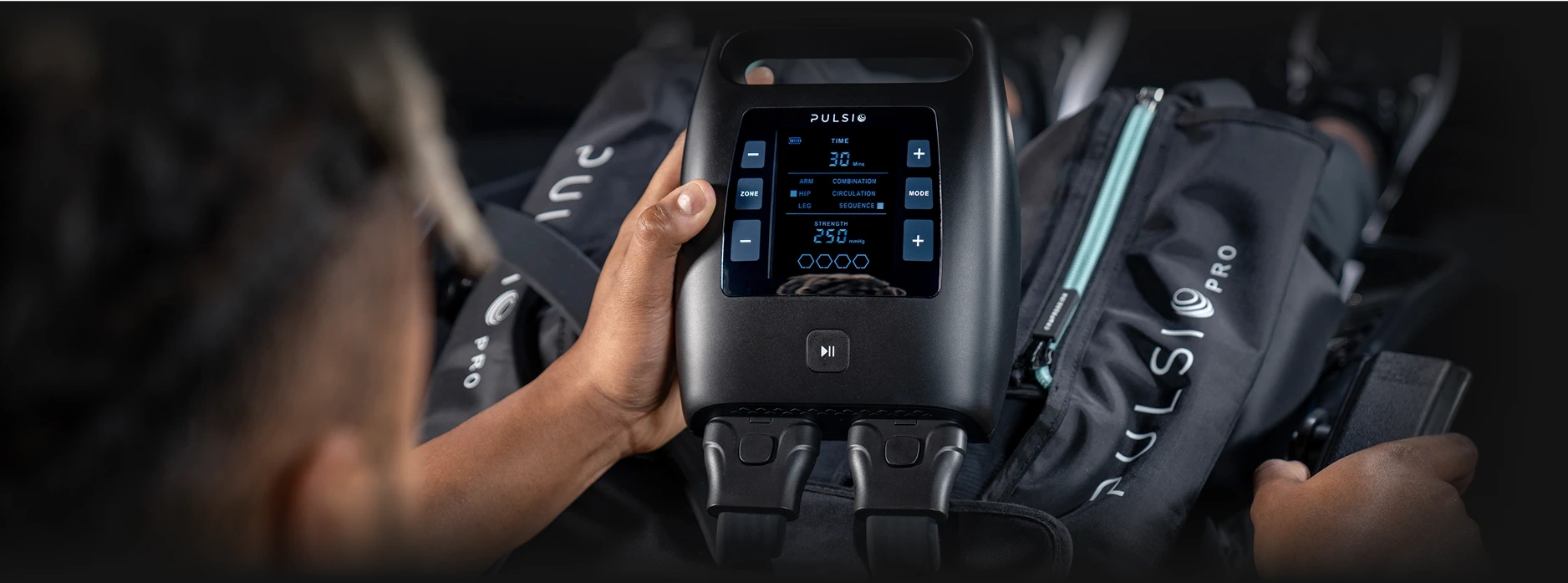 Person using a Pulsio Pro device, holding a control panel.